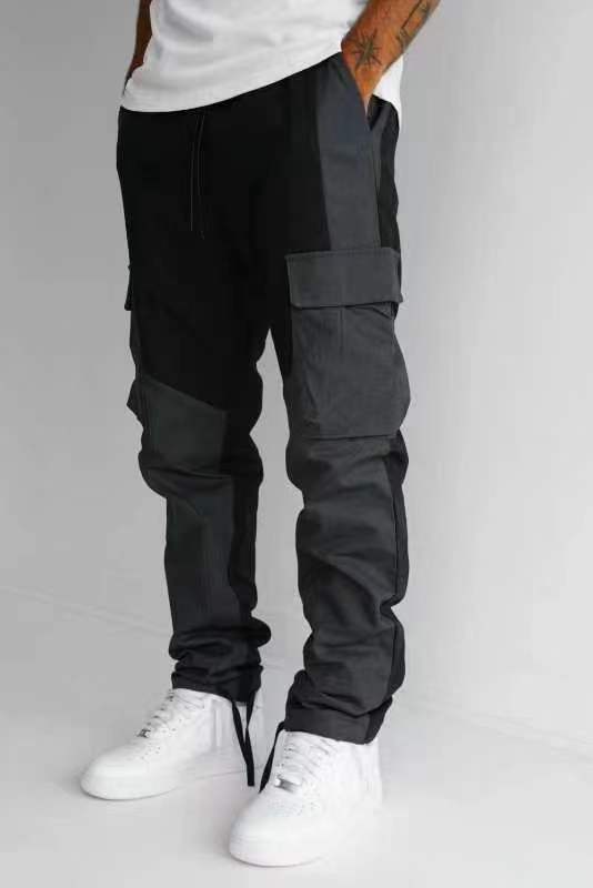 Black cargo trousers with large stitched thigh pockets, loose fit, cuffed ankles