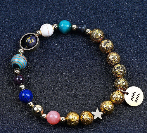 Beaded bracelet with gold beads, blue and teal stones, and star plus zodiac disc charms