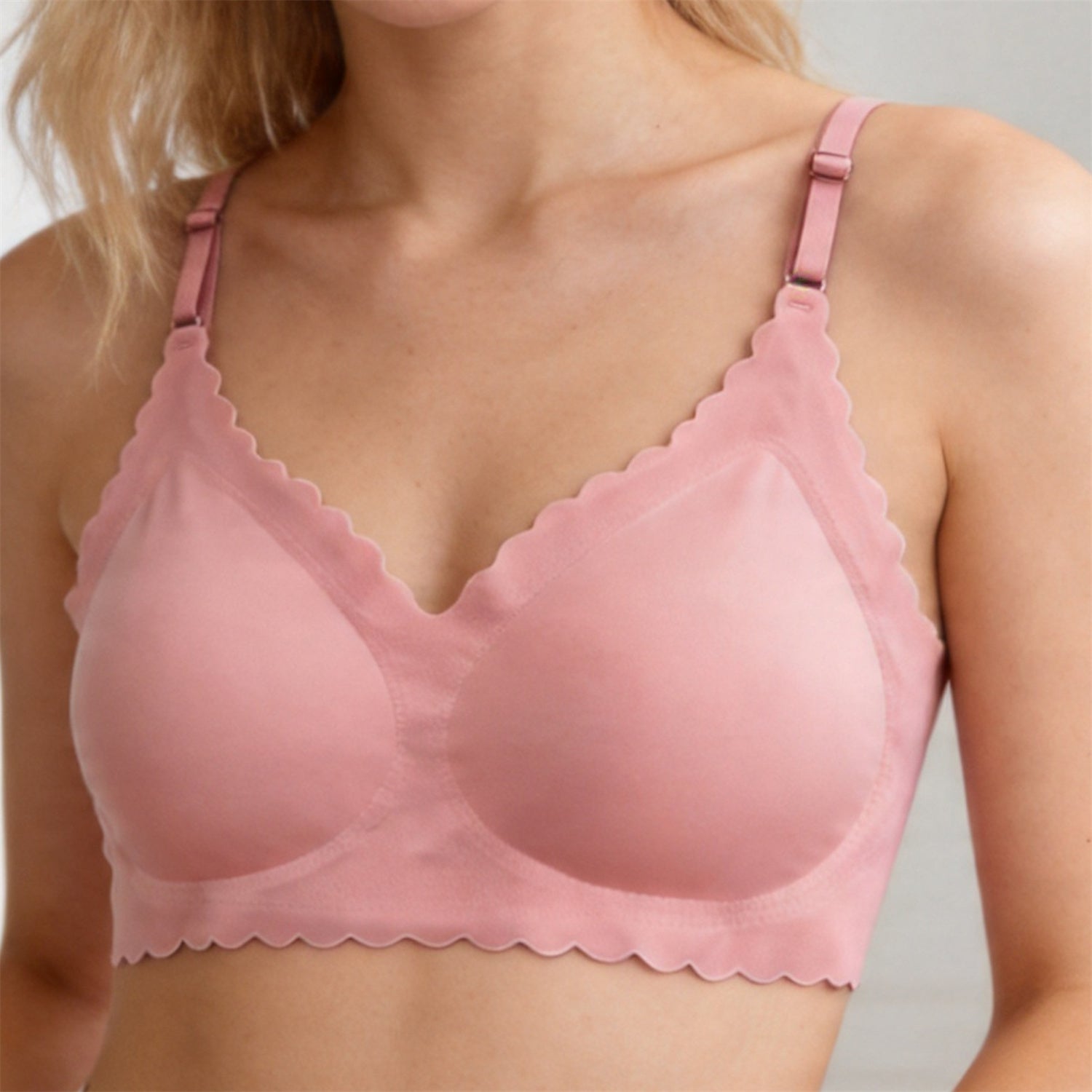 Pink wireless deep V bra with scalloped trim and adjustable shoulder straps