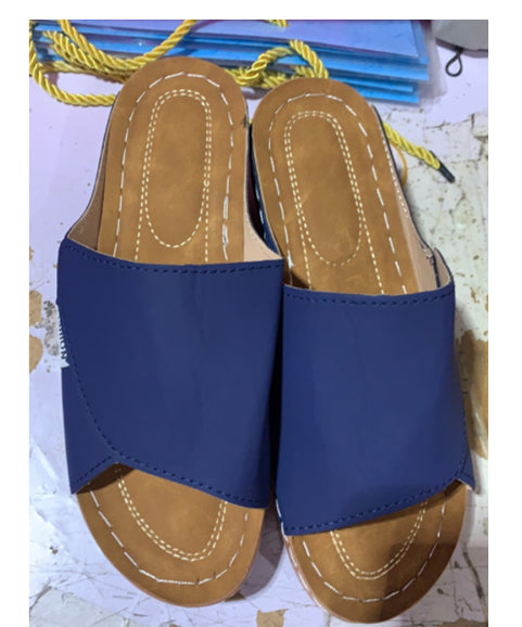Women’s dark blue wedge slides with open toe, tan insole, and stitched platform
