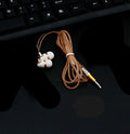 Wired in-ear headphones with white earbuds and brown braided cable with 3.5mm plug