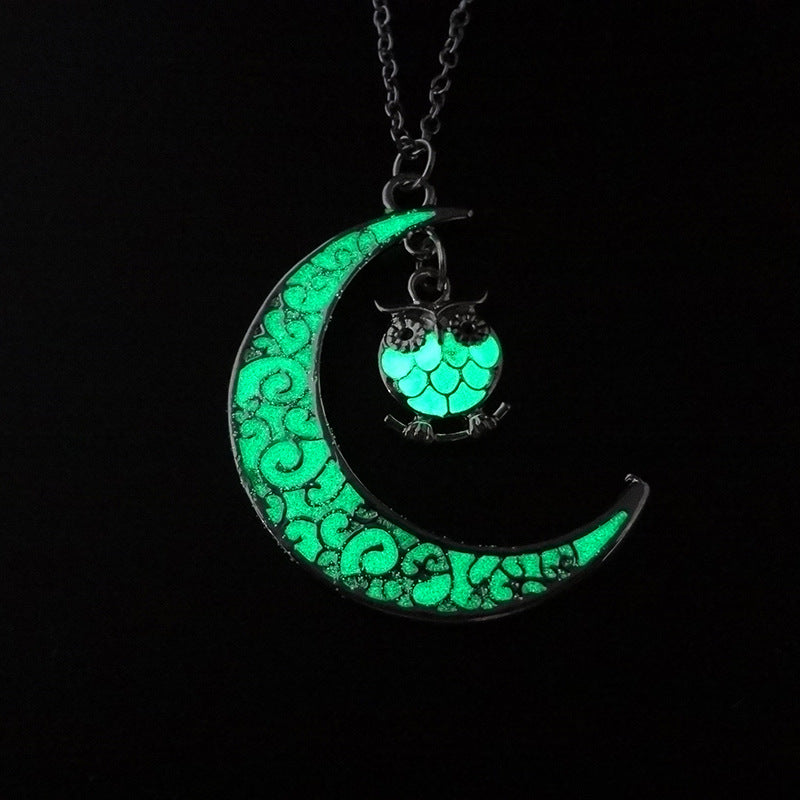 Crescent moon pendant necklace with green glowing owl on a silver chain