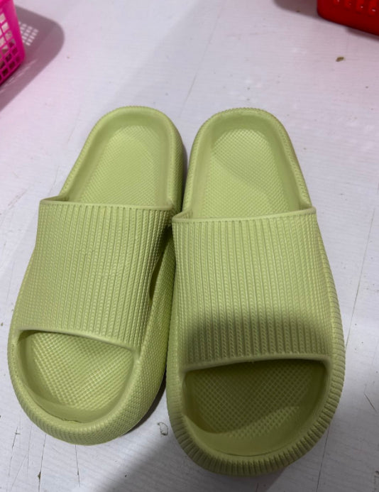 Light green knit slide slippers with open toe and cushioned sole.