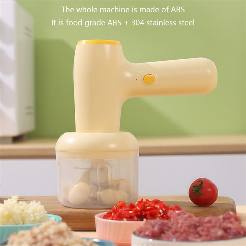Beige electric chopper with clear cup and meat chopping bowls on counter