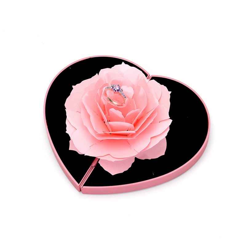 Heart-shaped ring box with pale pink rose flower on black insert and ring